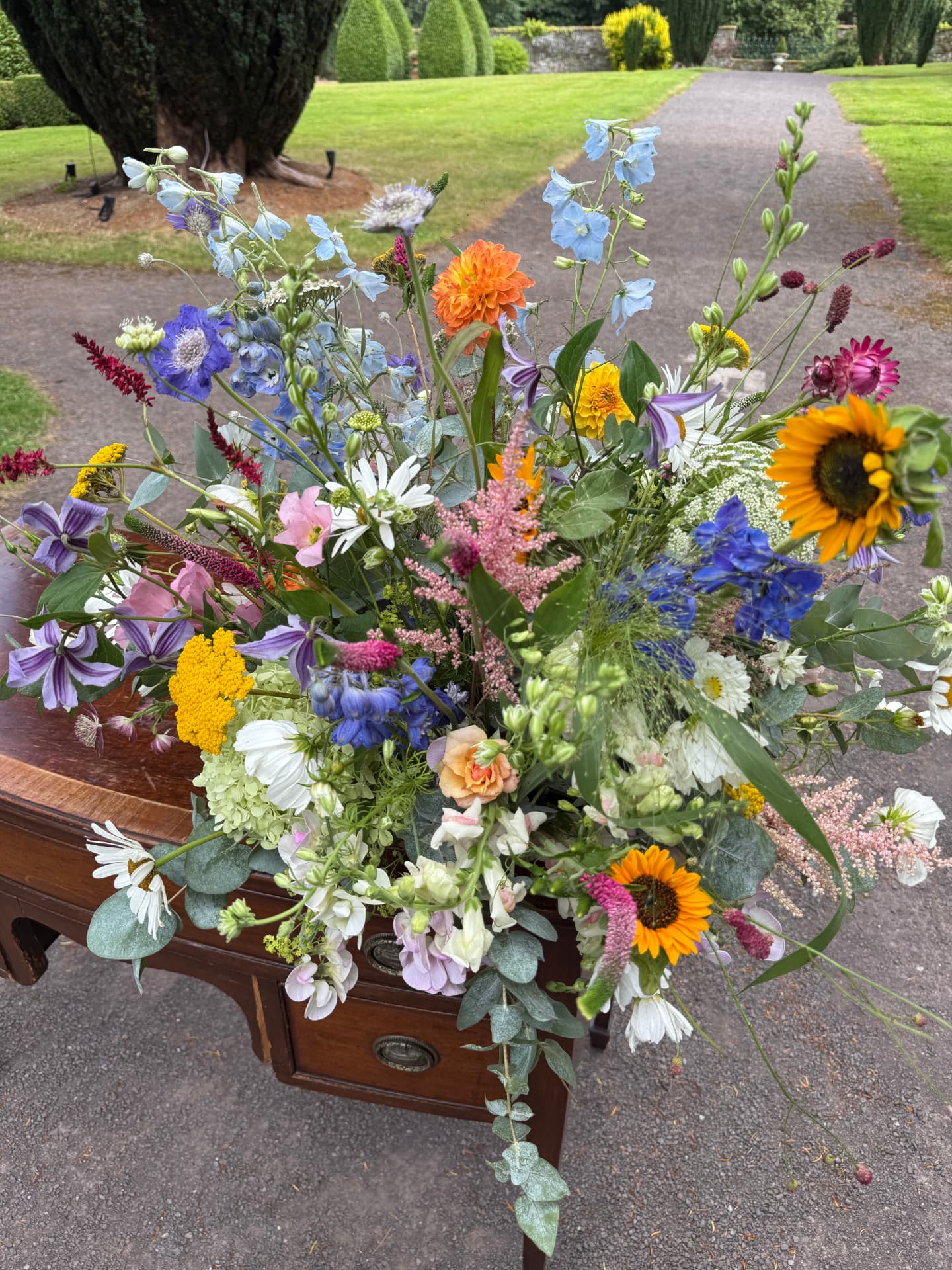 Wild seasonal wedding flower arrangement on an antique table