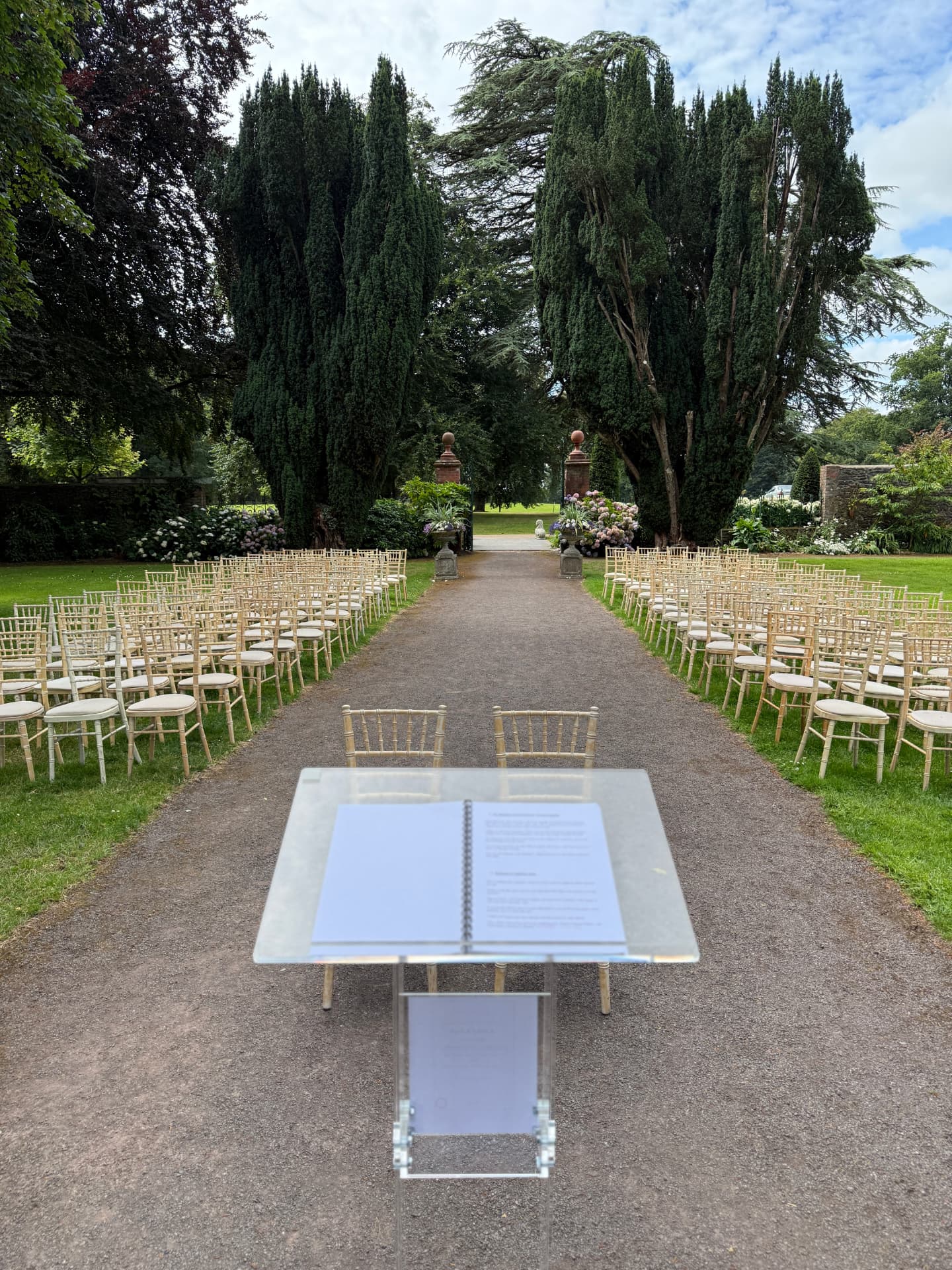 Ceremony aisle lined with chairs at a walled garden venue